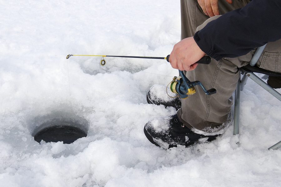 Modest success of ice fishing. Tiny Ruff (Acerina cernua) caught on a  fishing winter rod from under the ice with metallic lure. Fishing bragging  on th Stock Photo - Alamy